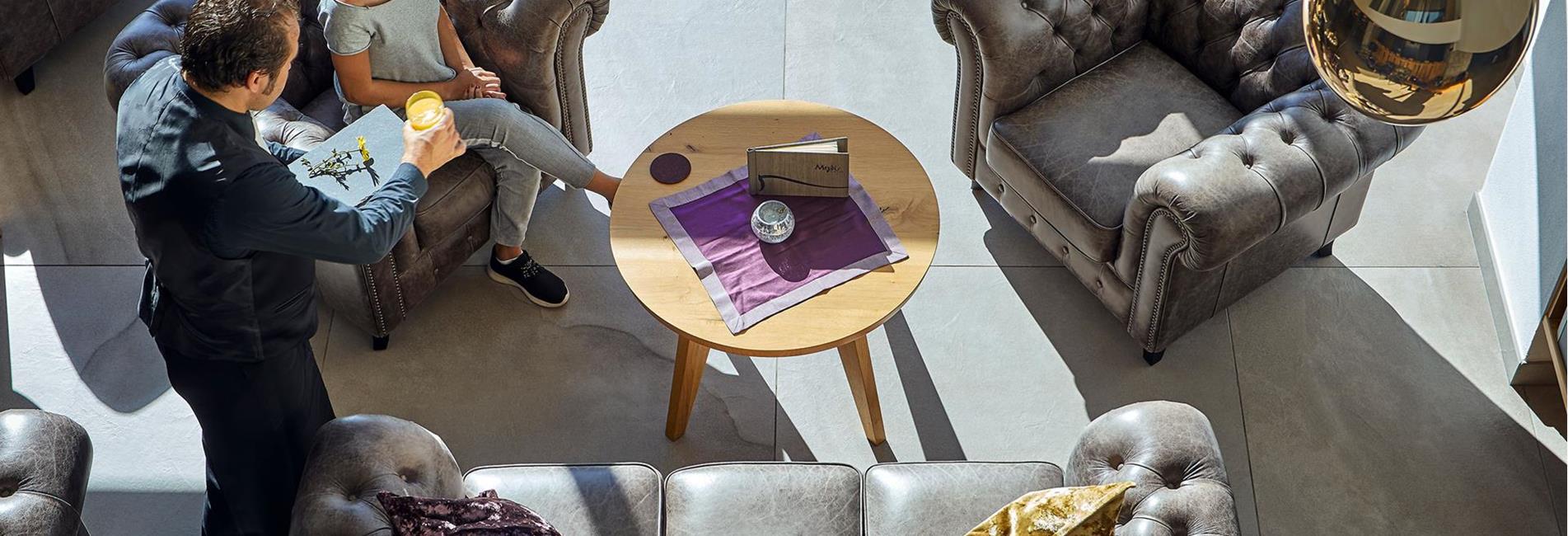 A waiter serves a woman a drink
