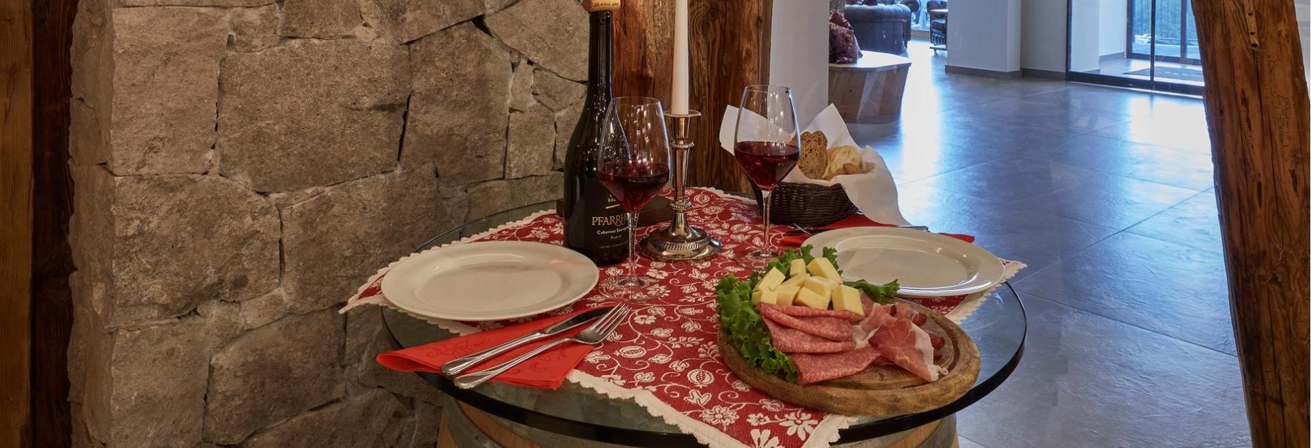Una tavola apparecchiata con vino rosso e una classica merenda altoatesin