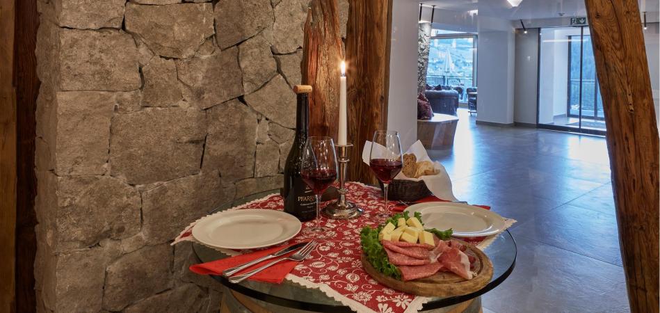 Una tavola apparecchiata con vino rosso e una classica merenda altoatesin